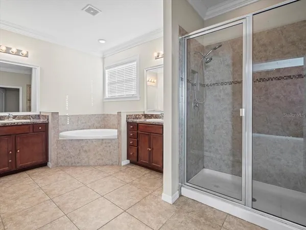 a bathroom with a granite countertop double vanity sink and a mirror