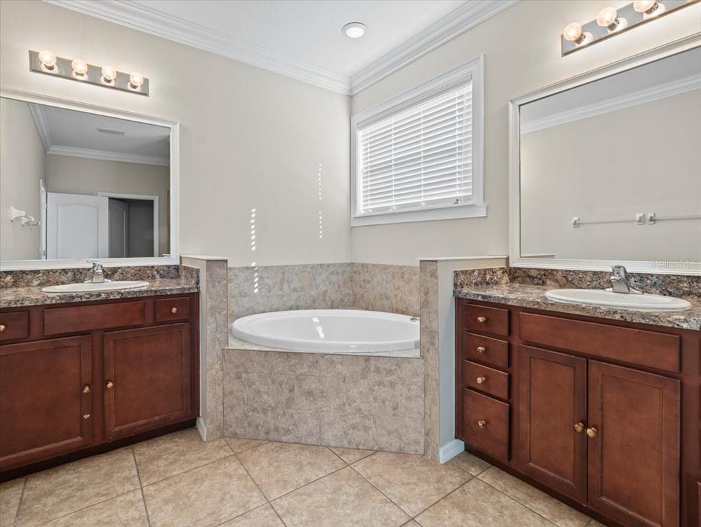 13366 Barkingside Place Spring Hill, FL 34609 - Photo 26 of 41 a bathroom with a granite countertop double vanity sink and a mirror