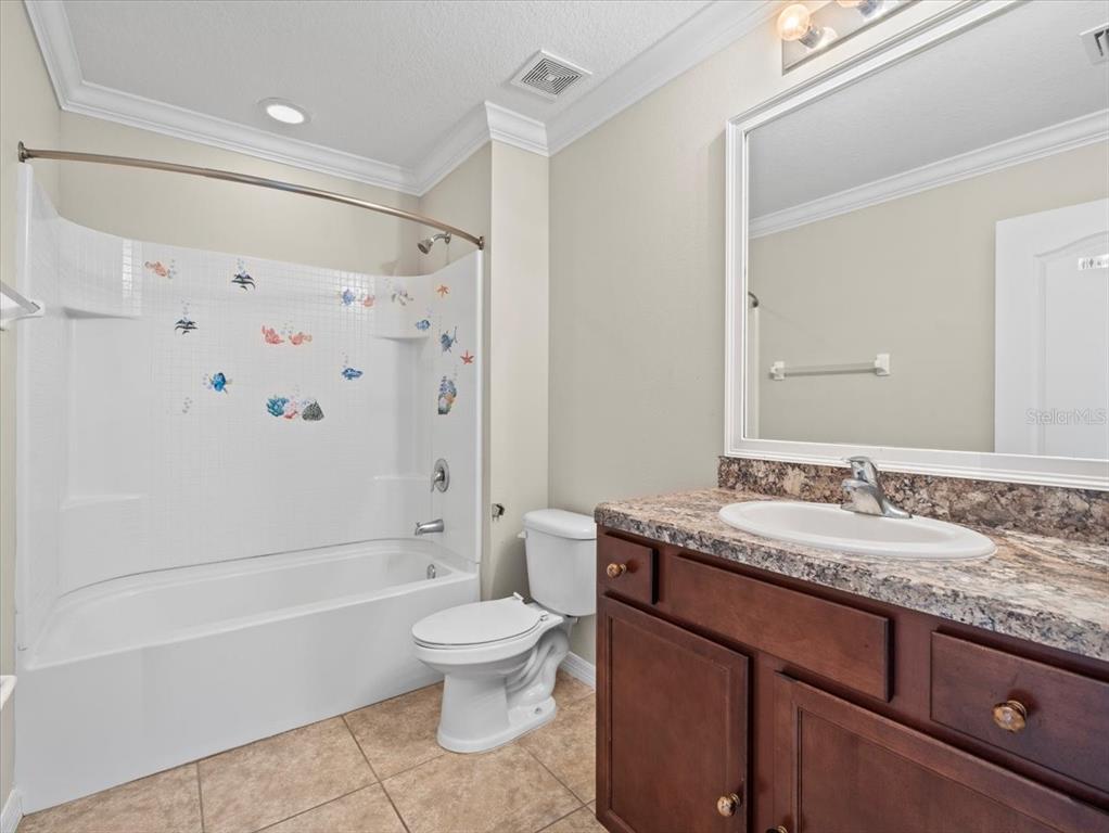 13366 Barkingside Place Spring Hill, FL 34609 - Photo 34 of 41 a bathroom with a granite countertop sink toilet mirror and bathtub