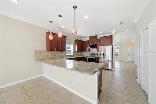 a kitchen with stainless steel appliances granite countertop a refrigerator sink and stove