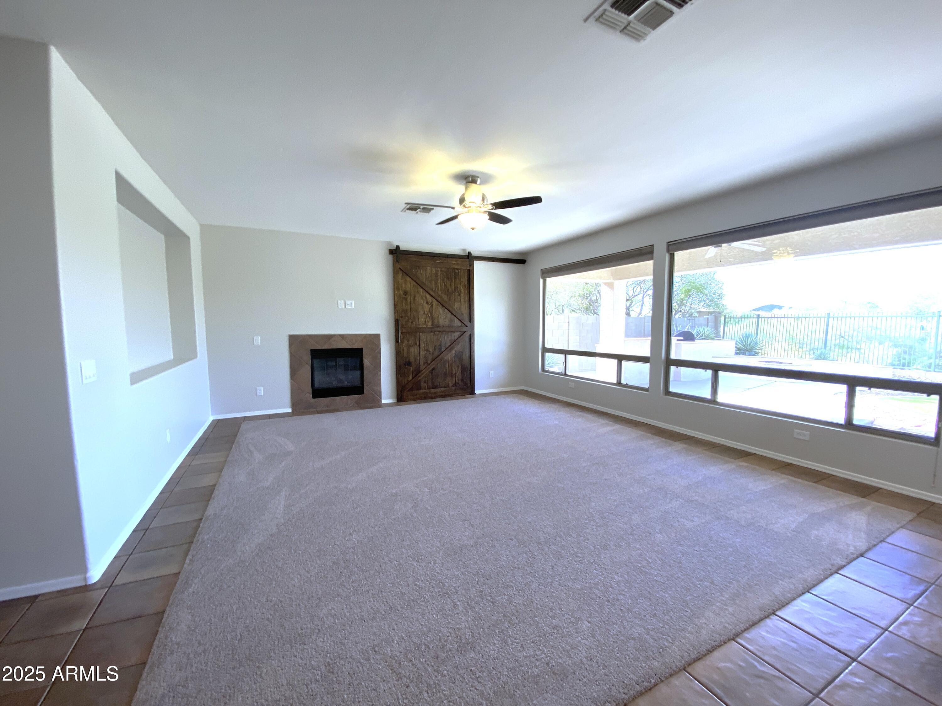 40320 North Exploration Trail Anthem, AZ 85086 - Photo 2 of 33 an empty room with fireplace and windows