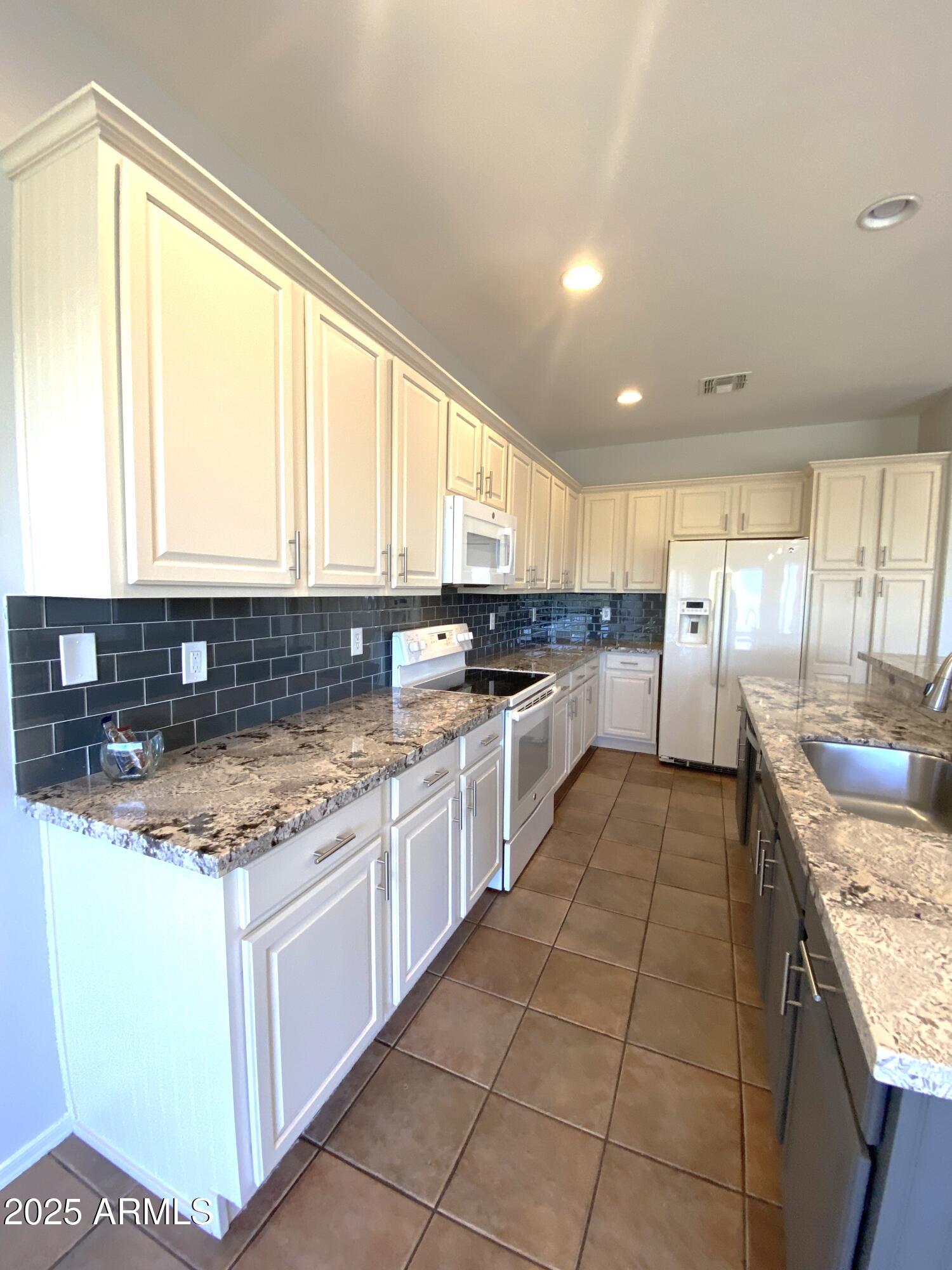 40320 North Exploration Trail Anthem, AZ 85086 - Photo 5 of 33 a large kitchen with stainless steel appliances granite countertop a stove a sink and a microwave