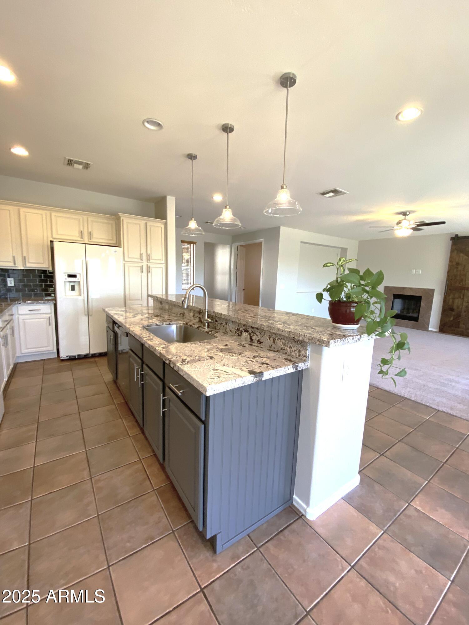 40320 North Exploration Trail Anthem, AZ 85086 - Photo 6 of 33 a kitchen with stainless steel appliances granite countertop a stove a sink dishwasher and a kitchen island