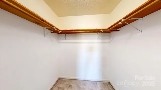 a view of walk in closet with clothes