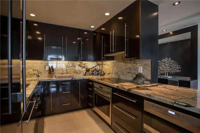 a kitchen with kitchen island granite countertop a sink and a stove