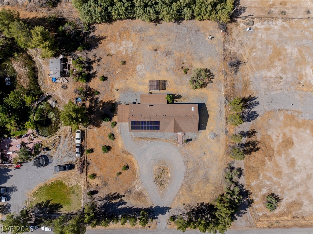 1890 West Dyer Road Pahrump, NV 89048 - Photo 26 of 40 Aerial view showcasing a secluded home with a private driveway, surrounded by natural landscape. Solar
