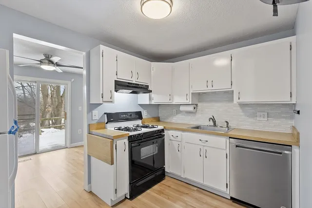 a kitchen with stainless steel appliances granite countertop a sink stove and cabinets
