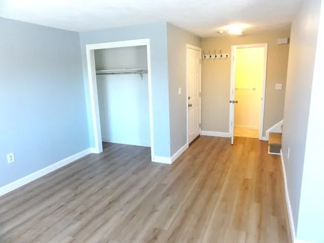 a view of a room with wooden floor and a window