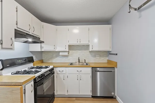 a kitchen with granite countertop a stove and a sink