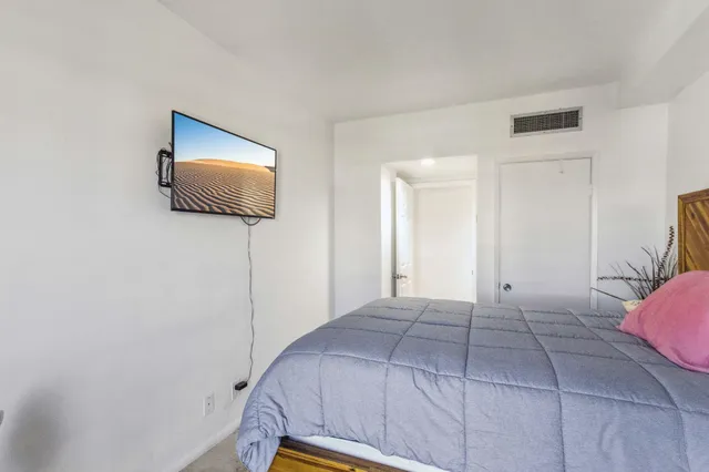 a bedroom with a bed and a flat screen tv