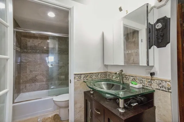 a bathroom with a sink a toilet and shower