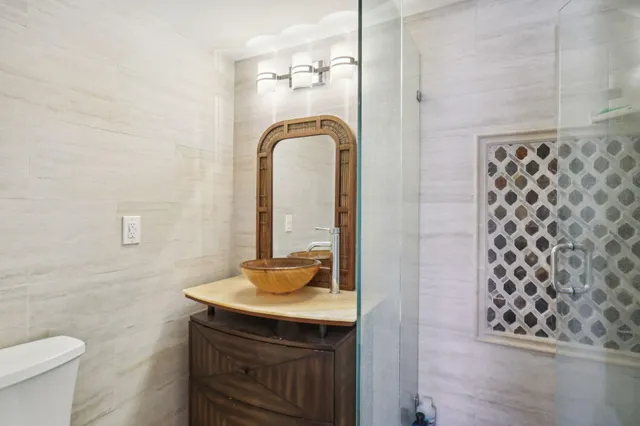 a bathroom with a sink a toilet and shower