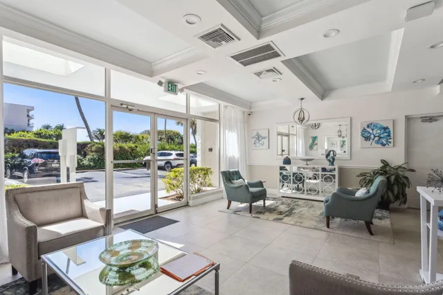 a living room with patio furniture and a floor to ceiling window