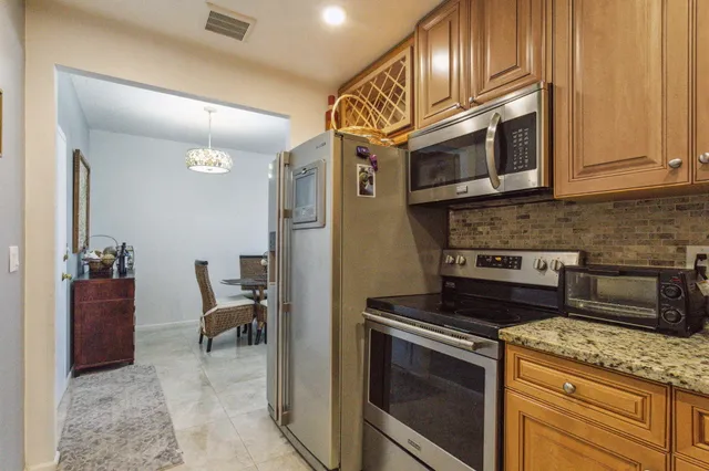 a kitchen with stainless steel appliances granite countertop a stove microwave and cabinets