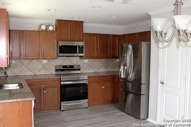 a kitchen with stainless steel appliances granite countertop a refrigerator stove and sink