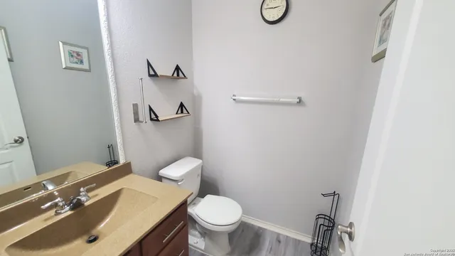 a bathroom with a granite countertop toilet sink and a mirror