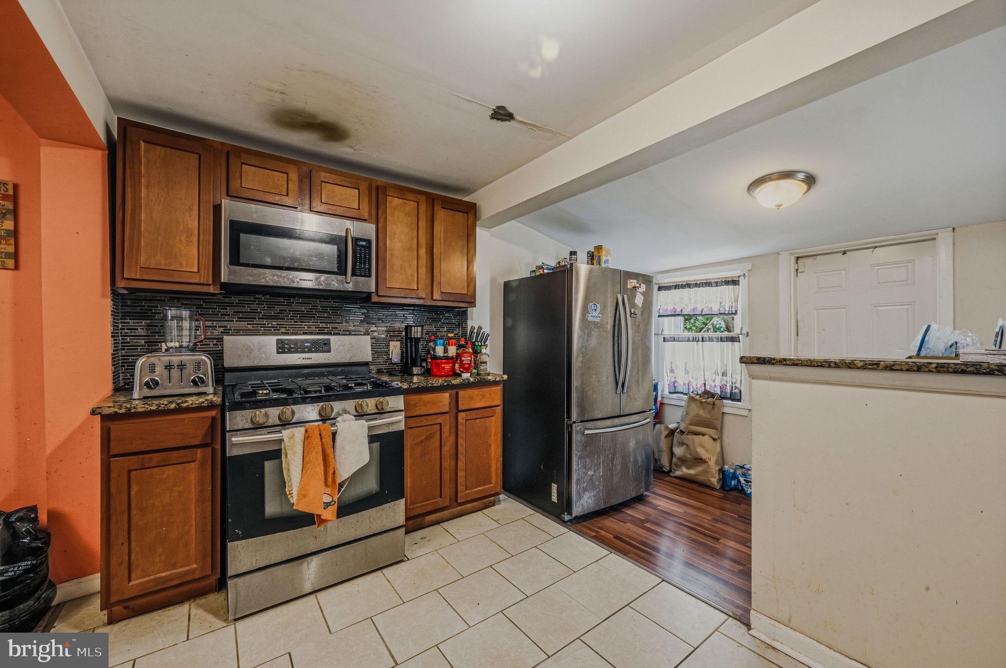 408 West 9th Street New Castle, DE 19720 - Photo 11 of 29 a kitchen with stainless steel appliances granite countertop a refrigerator a stove top oven a sink and dishwasher