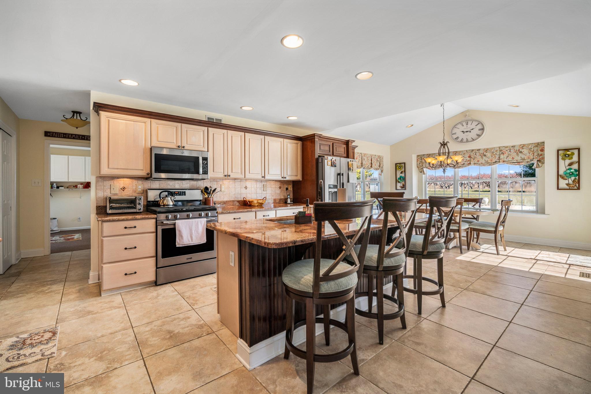 109 Brookside Way Mullica Hill, NJ 08062 - Photo 9 of 41 a kitchen with stainless steel appliances kitchen island granite countertop a stove a sink a dining table and chairs