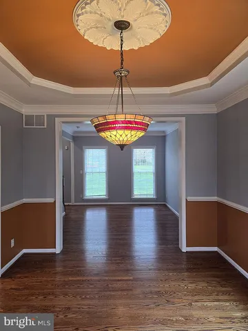 a view of a room with wooden floor and chandelier