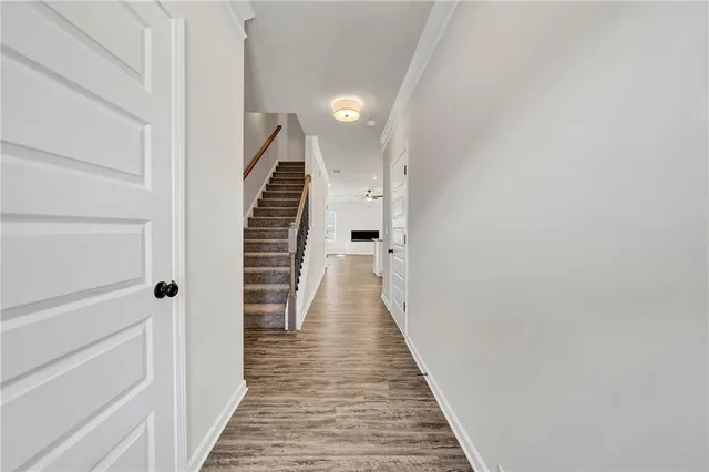 a kitchen with stainless steel appliances granite countertop a sink a refrigerator and a wooden floor