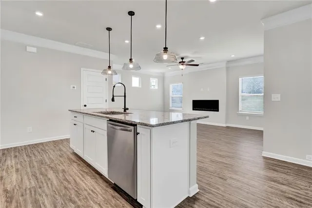 a view of an empty room with wooden floor closet and a window