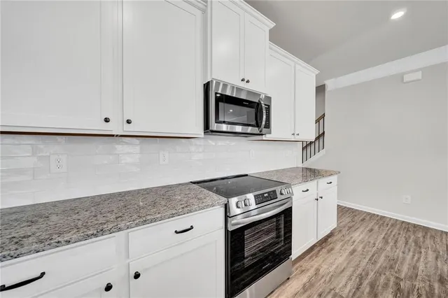 a view of a kitchen with wooden floor and a ceiling fan