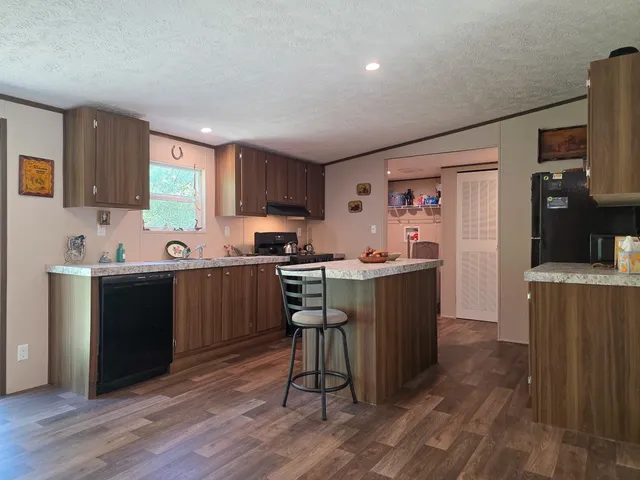 a kitchen with a sink cabinets and wooden floor