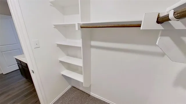 a view of walk in closet with empty racks