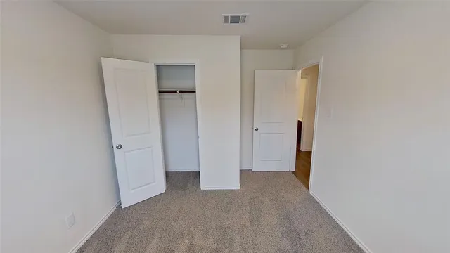 a view of a hallway with wooden floor and closet