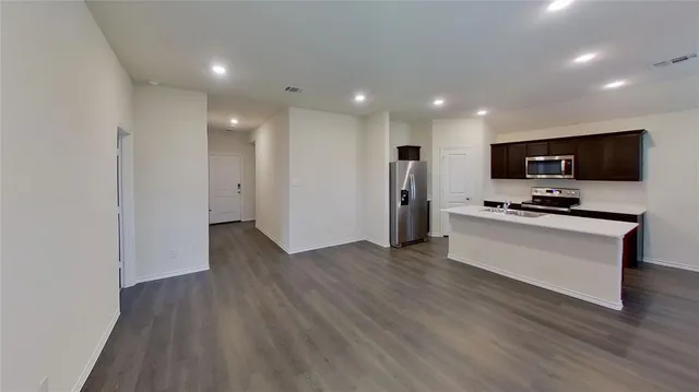 a view of kitchen with stainless steel appliances refrigerator stove microwave and cabinets
