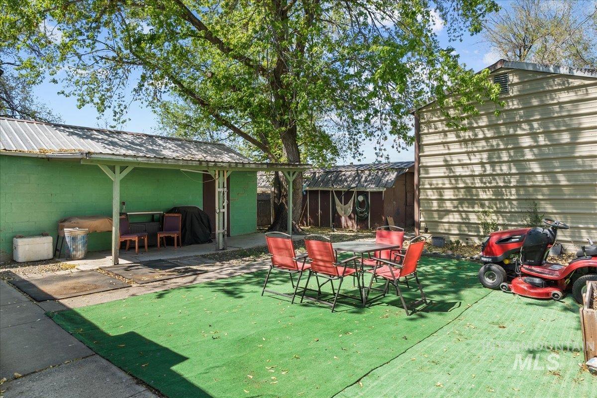 1958 East 1775 South Gooding, ID 83330 - Photo 43 of 49 Outdoor area featuring artificial turf, a covered patio with a metal roof, and a large shade tree