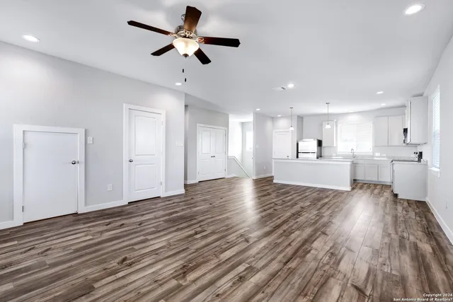 a view of a kitchen with wooden floor and a ceiling fan