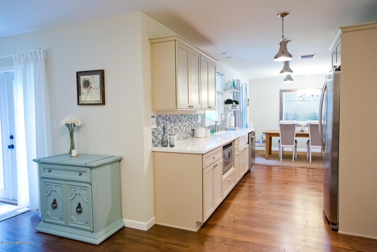 107 Saturn Road St. Augustine, FL 32086 - Photo 21 of 37 a large white kitchen with sink and wooden floors