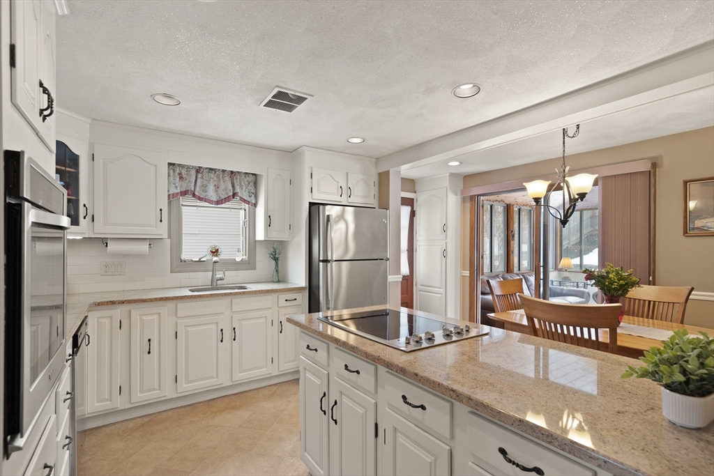 35 Longfellow Road Reading, MA 01867 - Photo 14 of 34 a kitchen with granite countertop a sink stainless steel appliances and cabinets