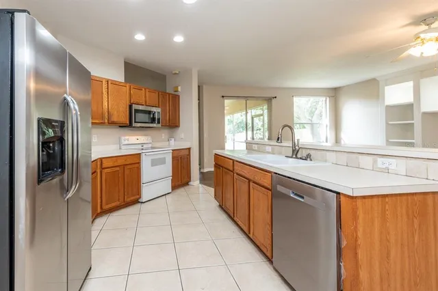 a kitchen with stainless steel appliances granite countertop a sink counter space cabinets and a large window