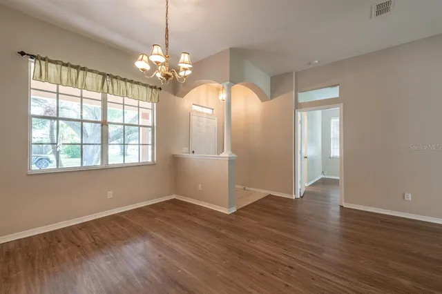 a view of a room with wooden floor and chandelier