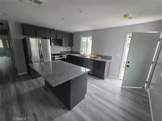 a kitchen with granite countertop a refrigerator and a sink