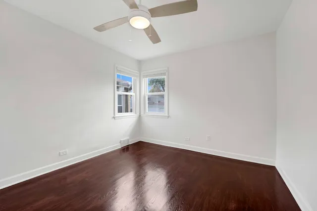 a view of a room with wooden floor and ceiling fan