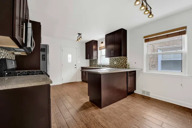 a kitchen with stainless steel appliances granite countertop a sink and a stove top oven