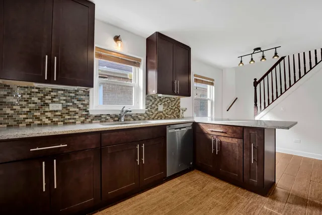 a kitchen with granite countertop a sink stainless steel appliances and cabinets