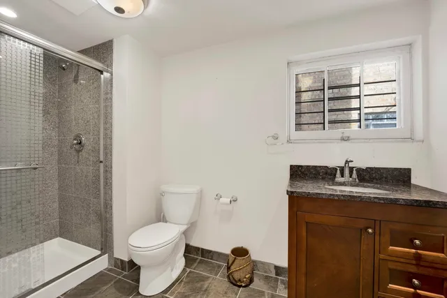 a bathroom with a granite countertop sink toilet and shower