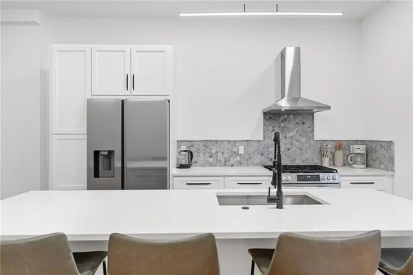 a kitchen with stainless steel appliances kitchen island sink refrigerator and stove