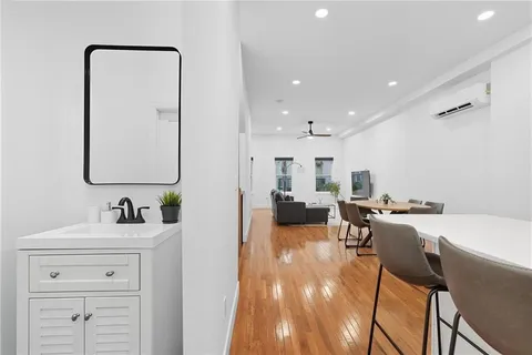 a living room with furniture a flat screen tv and a sink