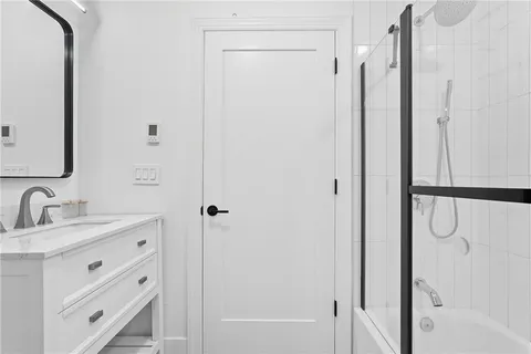 a bathroom with a double vanity sink mirror and shower