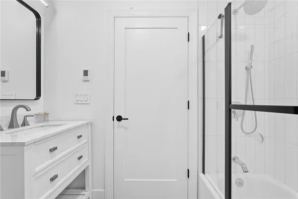 a bathroom with a double vanity sink mirror and shower