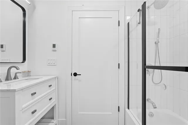 a bathroom with a double vanity sink mirror and shower