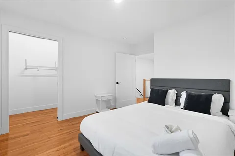 a bedroom with a bed and wooden floor