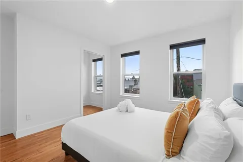 a bedroom with a bed and wooden floor