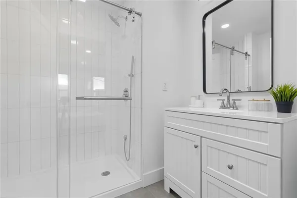 a bathroom with a shower sink and mirror