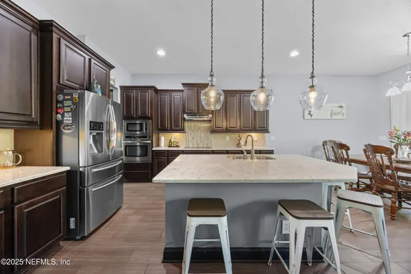 a kitchen with stainless steel appliances granite countertop counter space cabinets a sink and a center island